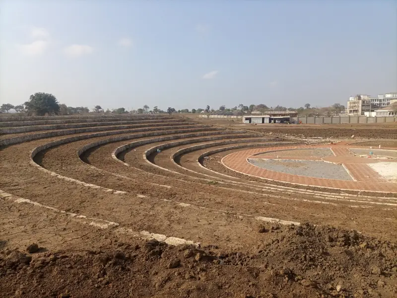 Before: Kilifi park amphitheatre during earthworks: bare terraced soil around the paved stage